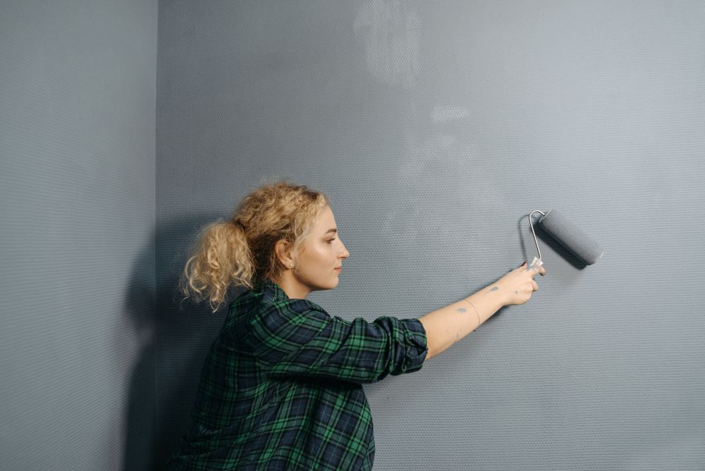 Painting a wall with a roller in a soft muted color