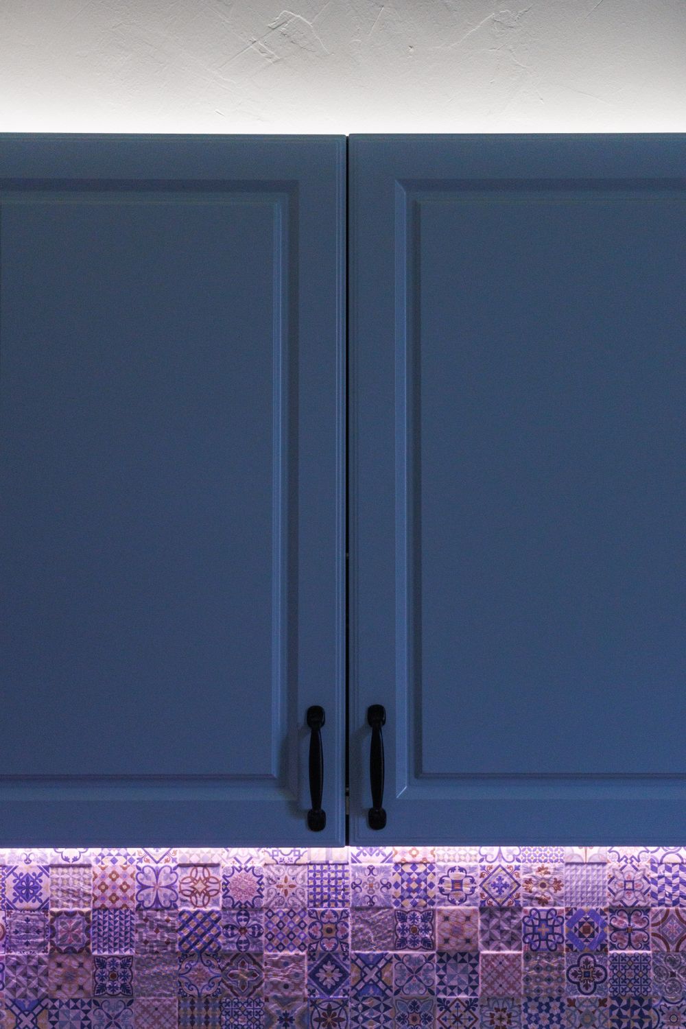 Modern kitchen with blue painted cabinetry and patterned tile