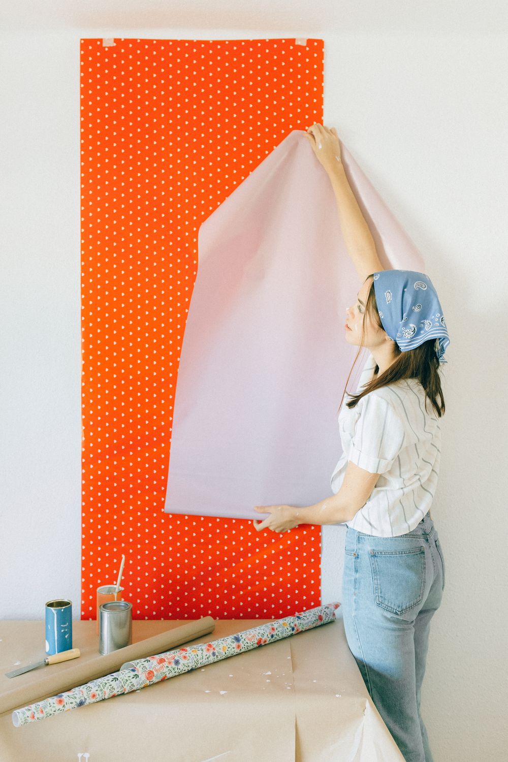 Applying removable polka dot wallpaper during a home makeover